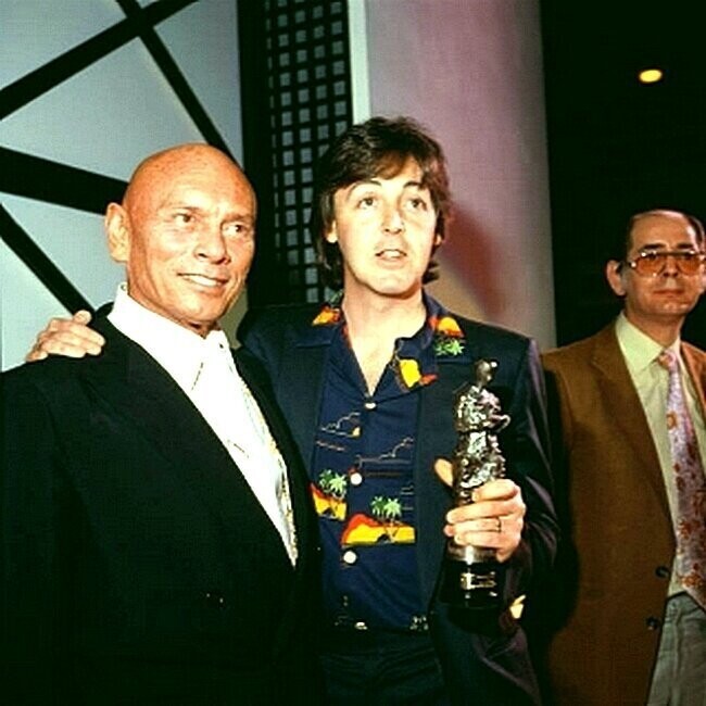 Актер с русскими корнями Юл Бриннер (1920 - 1985) с бывшим битлом Полом Маккартни после вручения певцу награды Айвор Новелло в Grosvenor House в Лондоне, 9 мая 1980 года.