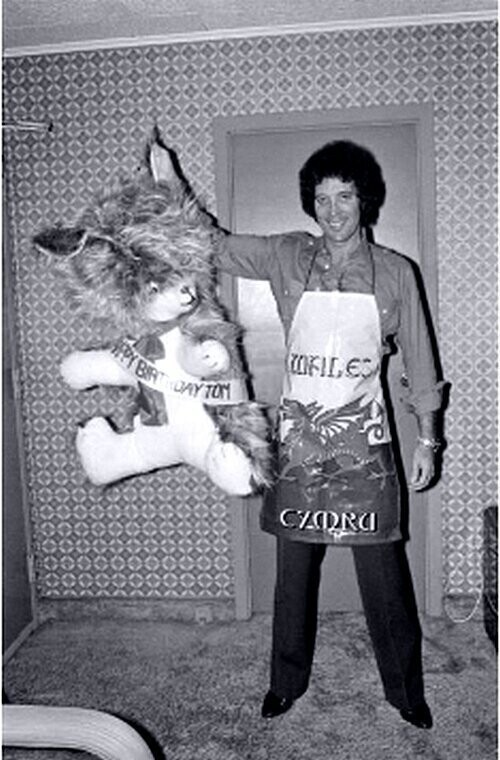 Том Джонс позирует с подарками от фанатов на музыкальном фестивале в Вестбери, недалеко от Нью-Йорка. 27 июня 1980 года.