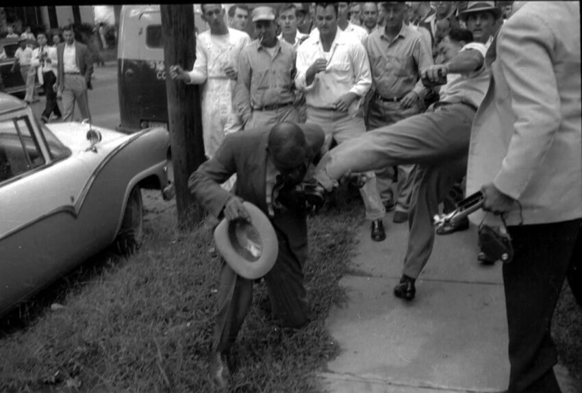 Группа  жителей Литл-Рока, штат Арканзас, занимается избиением и изгнанием из своего города чернокожего журналиста Алекса Уилсона (1961 год)