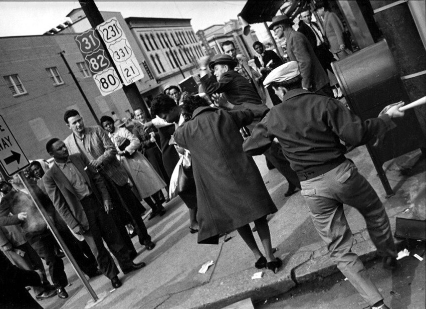 Белый американец с битой набрасывается на чернокожую девушку, которая посмела предпринять попытку войти в кафе, ранее предназначавшееся только для белых (1958 год)