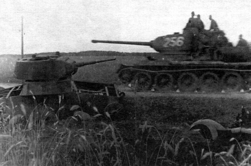 Cоветский танк Т-34-85 проезжает мимо советского же танка Т-26, подбитого в 1941 году. 