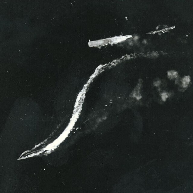 Обездвиженный «Рюдзё» (справа от центра) после атаки 24 августа 1942 года, фотография с высотных бомбардировщиков B-17. Эсминец «Амацукадзэ» (в центре внизу) отплывает от «Рюдзё» на полной скорости, а 