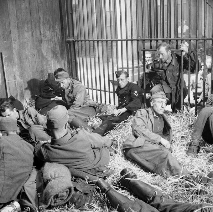 Пленные немецкие солдаты в львиной клетке Антверпенского зоопарка.