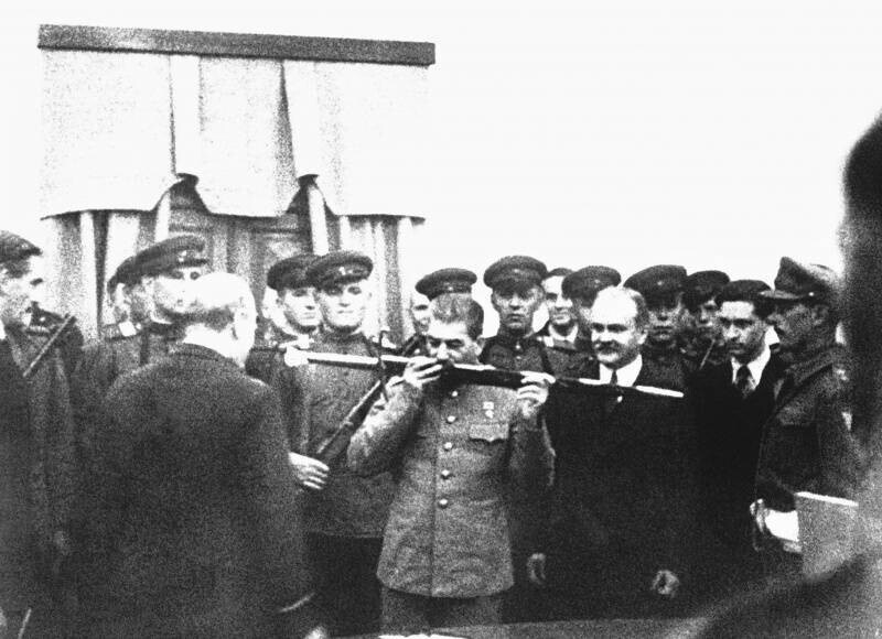 Иосиф Виссарионович Сталин целует «Меч Сталинграда» на церемонии вручения в конференц-зале советского посольства во время Тегеранской конференции. Перед И.В. Сталиным стоит премьер-министра Великобритании Уинстон Черчилль. 
