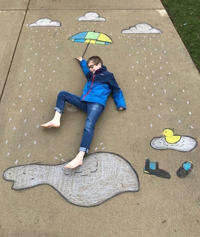 Девочка рисует на тротуаре пейзажи, чтобы её брат мог «путешествовать» во время карантина