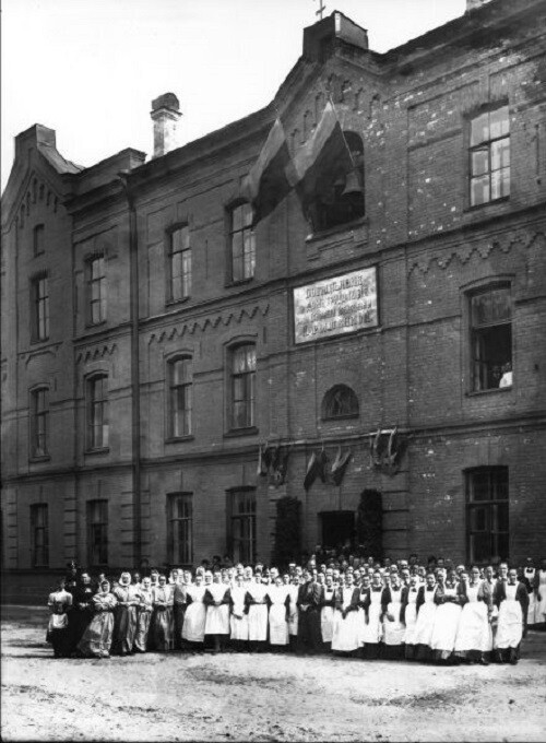 Группа воспитанниц у здания Приюта императора Александра III для девочек Петроградского Дамского благотворительного тюремного комитета. 1915