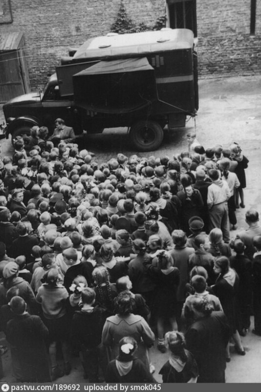 Школьники смотрят фильм о безопасности дорожного движения, показываемый на киноэкране, размещённом в агитационной машине Киевского управления милиции; 1959-й год