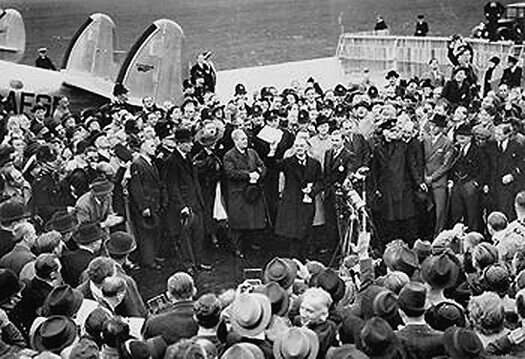 Невилл Чемберлен выступает с краткой речью по прибытию в аэропорт Хестон 30 сентября 1938 после закрытия Мюнхенской конференции