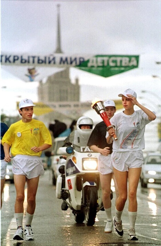 Спортсмены несут факел Всемирных юношеских игр в Москве, за день до начала игр на стадионе в Лужниках, 10 июля, 1998 год