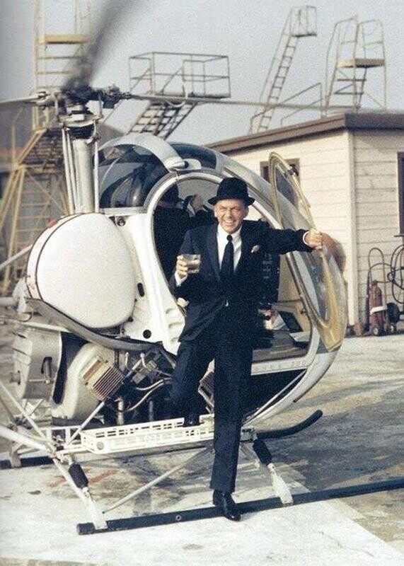 Фрэнк Синатра выходит из вертолета с напитком в руке, 1960-е