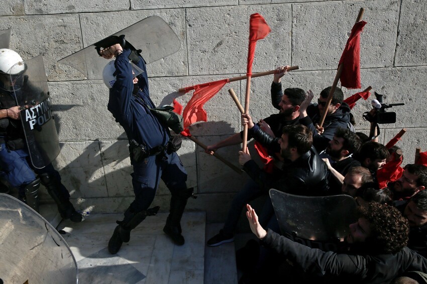 Столкновения протестующих с полицией при охране общественного порядка во время демонстрации у здания парламента против запланированных правительственных реформ в Афинах, Греция, 12 января 2018 года.