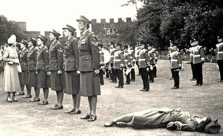 Молодая девушка из почетного женского королевского армейского корпуса потеряла сознание от жаркой погоды во время встречи с принцессой Елизаветой. Шрусбери, Англия, 6 июля 1949 года
