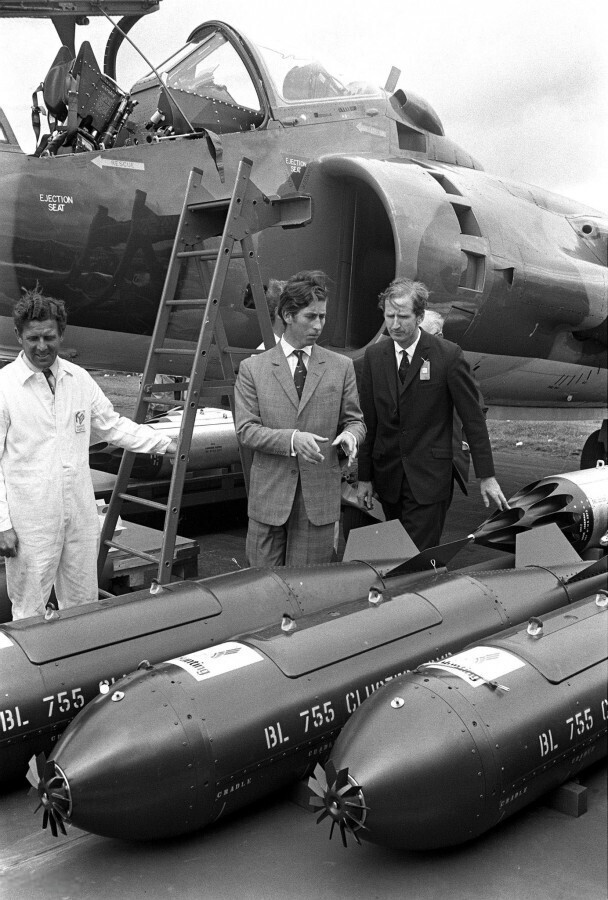 8 сентября 1970 года. Хэмпшир, Англия, Его Королевское Высочество принц Чарльз смотрит на вооружение, которое может нести самолет T2 Harrier Jump Jet. Авиашоу Фарнборо.