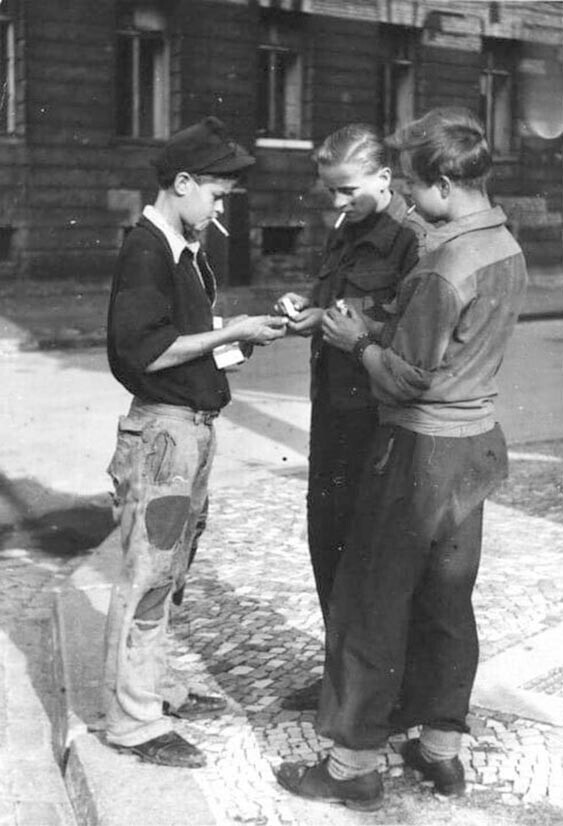 Молодые люди, совершающие сделку с использованием сигарет в качестве денег в Западной Германии. 1948 год.