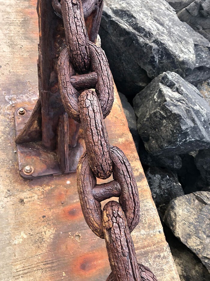 Из-за коррозии старая металлическая цепь стала похожа на деревянную