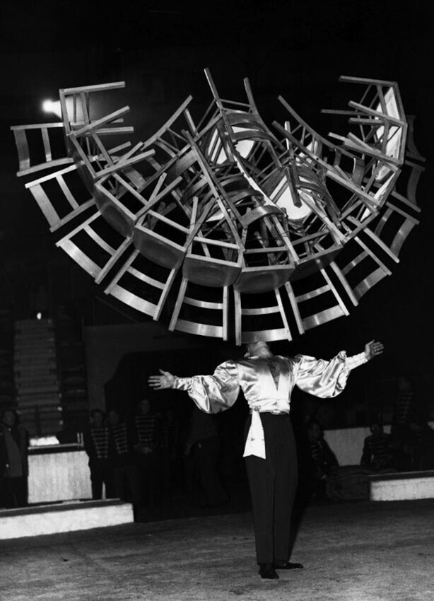 Артист цирка Фред Лони удерживает в зубах 22 деревянных стула, каждый весом девять фунтов, в цирке Тома Арнольда. Лондон, Англия, 1956 год.