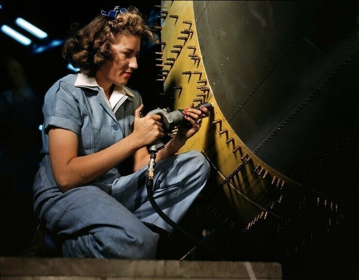 Октябрь 1942 г. Клепальщица на работе на бомбардировщике на заводе Consolidated Aircraft в Форт-Уорт. Фото Говарда Холлема