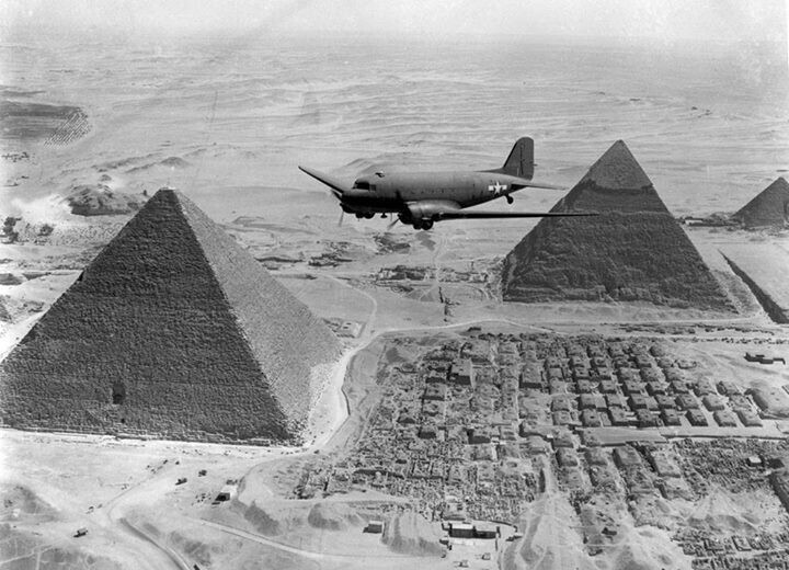 Транспортный самолет США Douglas C-47 Skytrain пролетает над некрополем Гизы в Египте, 1943 год.