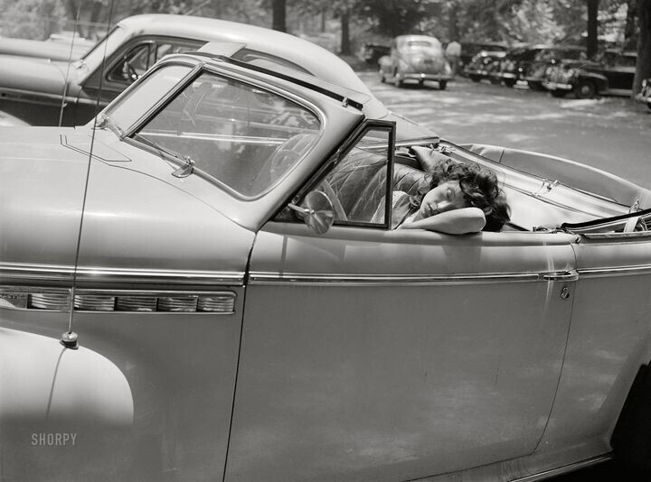 Разморенная летней жарой девушка задремала на парковке в своем автомобиле, Вашингтон, июль 1942 года. Фото Marjory Collins