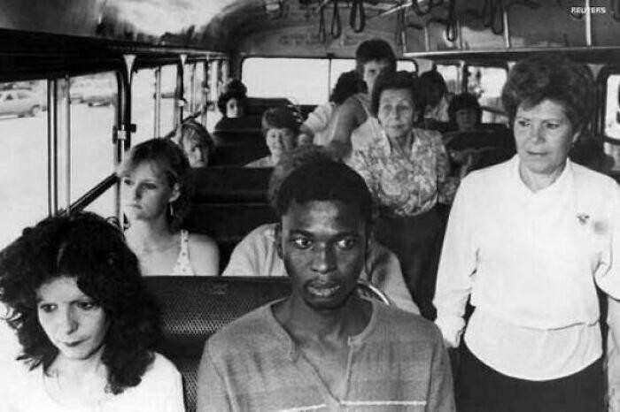 13. Мужчина в Дурбане едет на автобусе, предназначенном для белых пассажиров, в знак протеста против политики апартеида Южной Африки. 1986 год