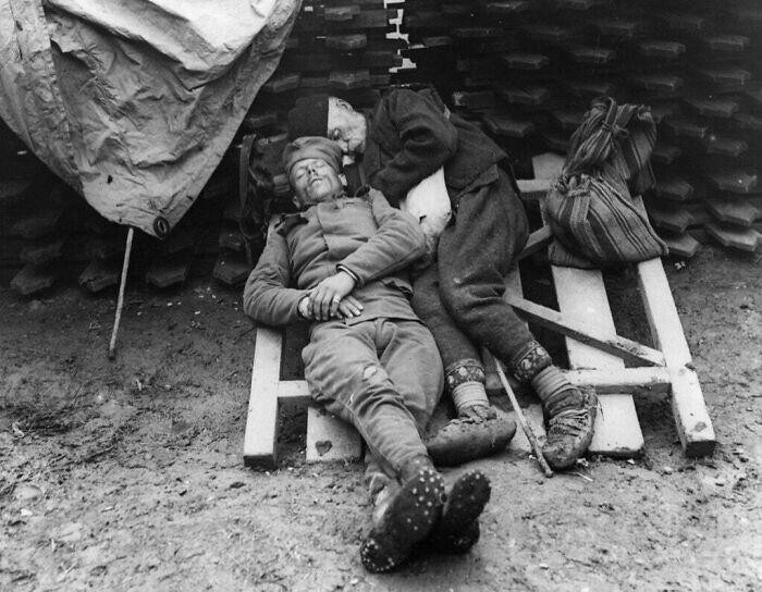 10. Сербский солдат спит рядом с отцом, который навестил его на передовой возле Белграда, 1914/1915 год