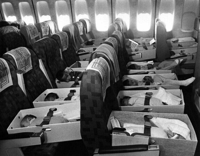 Младенцы, потерявшие родителей во время войны во Вьетнаме, переправляются по воздуху в США для усыновления, 1975 г.