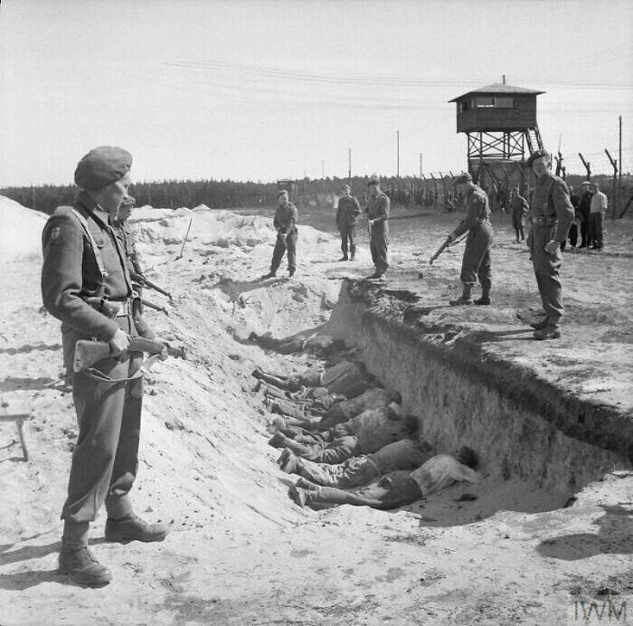 Немецкие гвардейцы СС, измученные принудительным трудом по уборке трупов в Берген-Бельзене. Британские солдаты разрешили ненадолго отдохнуть лежа лицом вниз в одной из пустых братских могил, 1945г.