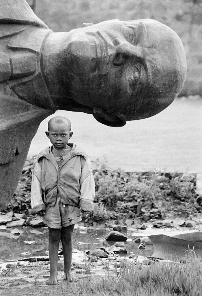 Мальчик стоит перед упавшей статуей Ленина. Эфиопия, 1991 год.