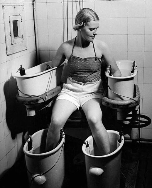 Женщина держит ноги и руки в вёдрах с водой, через которрую проводят электрический ток. В 1930-ые предполагалось, что это улучшает кровообращение.