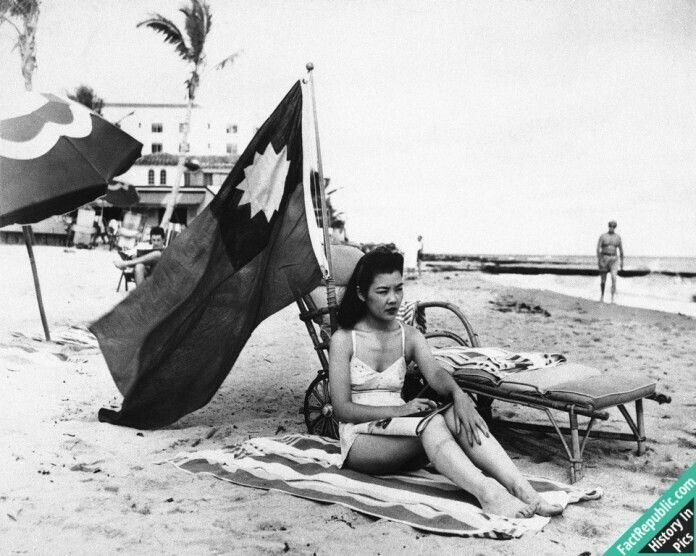 Хозяйка китайского ресторана в Майами Рут Ли отдыхает на пляже под китайским флагом, чтобы не быть принятой за японку в первые дни после налета на Перл Харбор, декабрь 1941г.
