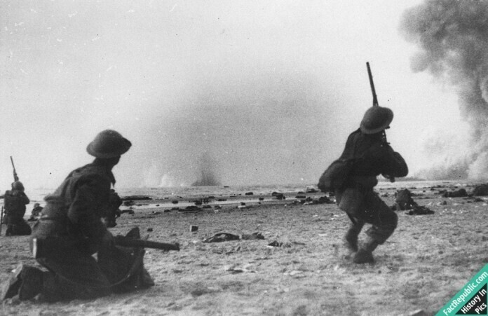 Британский солдат пытается сбить немецкий бомбардировщик при налете на Дюнкерк, май 1940