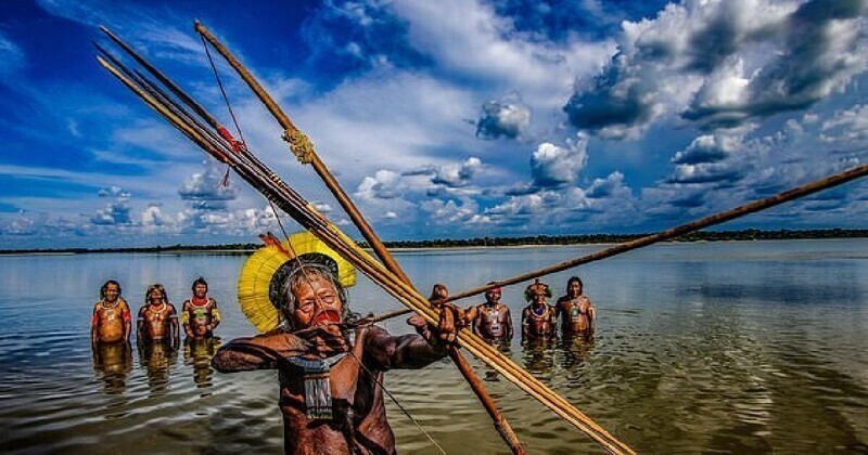 89-летний вождь племени, охотящийся с луком и стрелами в небольшой бухте