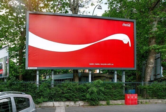 "Coca-Cola: открой, насладись, посодействуй переработке мусора вместе с нами!" Белая линия на рекламном биллборде напитка указывает на урны для раздельного сбора отходов