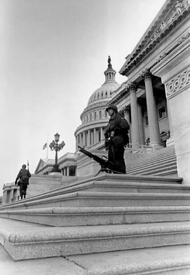 Солдат стоит рядом со своим пулеметом М60, установленным на ступенях при входе в Капитолий США во время визита Мартина Лютера Кинга в здание.