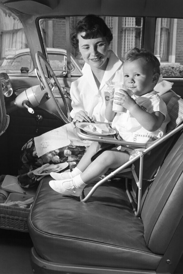 Ребенок перекусывает в автокресле. США, 3 апреля 1960 года.