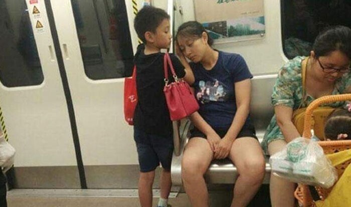 Мальчик уступил место женщине с коляской и встал возле задремавшей мамы, взяв еесумки