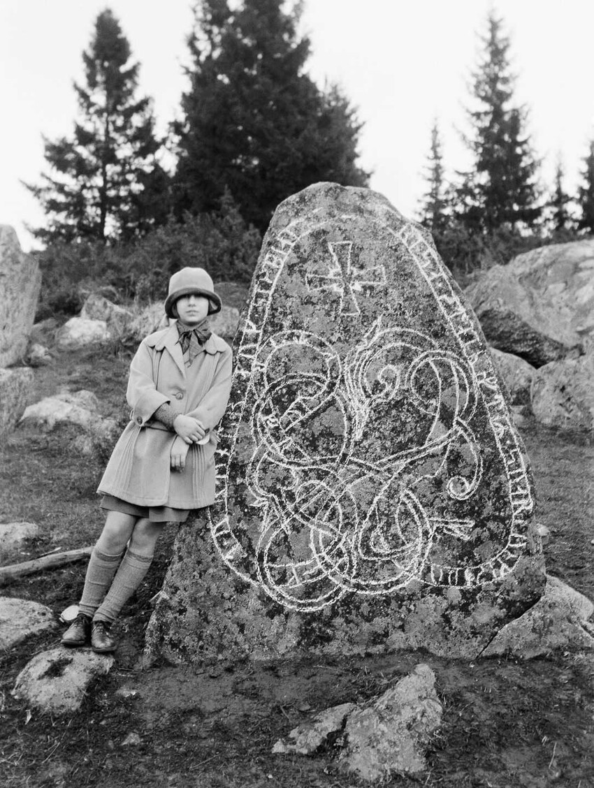 Девушка с руническим камнем в Лейсте. Надпись гласит: «Вигдьярв, Йорунд и Сигбьёрн поставили камень в память о Свартунге, их отце».