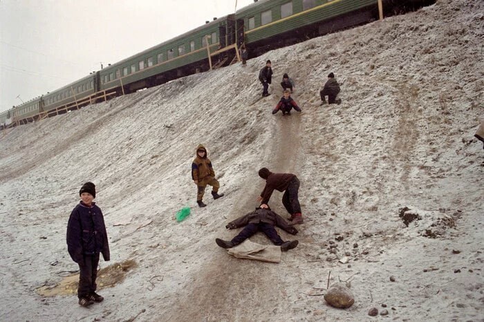 Дети катаются с горки рядом с железной дорогой, Россия, 1999 год