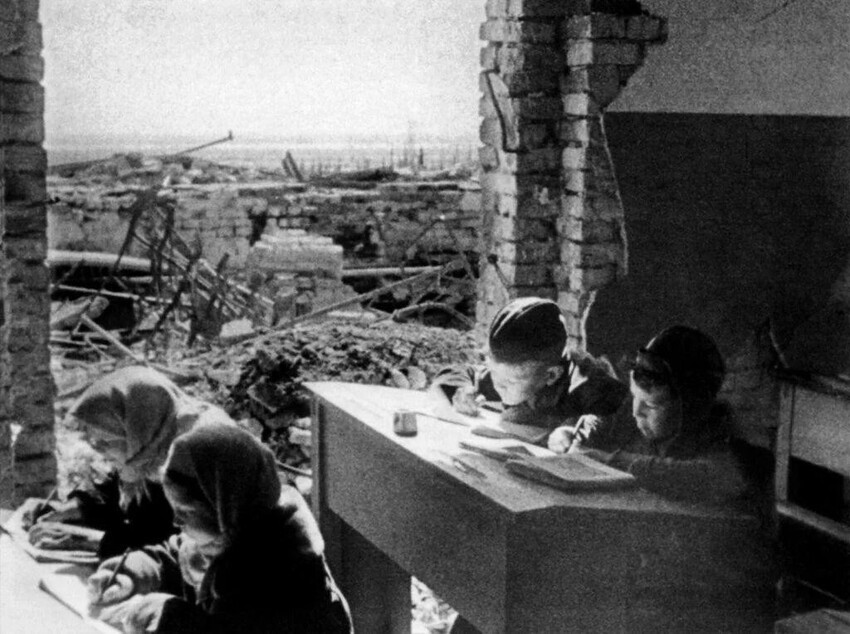 Дети за партами разрушенной школы в Сталинграде. СССР, весна 1943 года