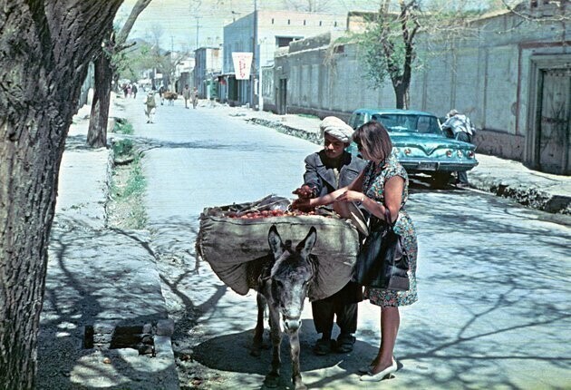 Филолог Марианна Чумандрина (1929–1969), первая супруга Александра Грюнберга, покупает сливы у торговца-пуштуна. На заднем плане можно разглядеть вывеску представительства компании «Аэрофлот». Кабул, около 1965 года