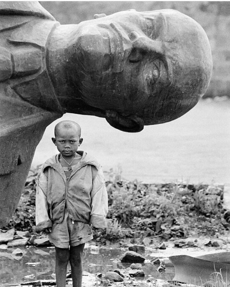Мальчик на фоне снесенной статуи Ленина, Эфиопия, 1991 г.