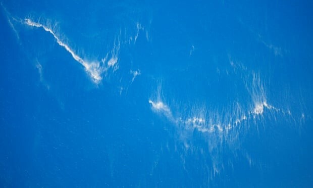 Еще в субботу спасательные службы предположили, что подводная лодка могла треснуть под давлением воды. На снимке с самолета видны следы топлива: