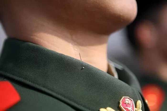 Булавка, торчащая из воротника кителя, помогает китайским военным сохранять правильную осанку