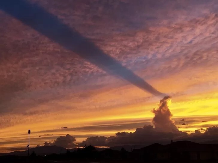Эпичное зрелище: облако отбрасывает длинную тень на другие облака