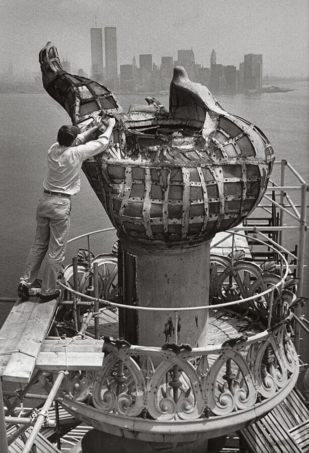 Рабочие ухаживают за факелом Статуи Свободы в Нью-Йорке. При подготовке к снятию факела в 1985 году для реставрации отдельные стекла были заклеены лентой, чтобы они не выпали с места.