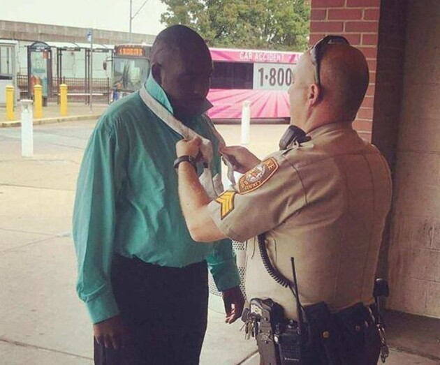 3. Офицер полиции помогает мужчине завязать галстук перед собеседованием о приеме на работу