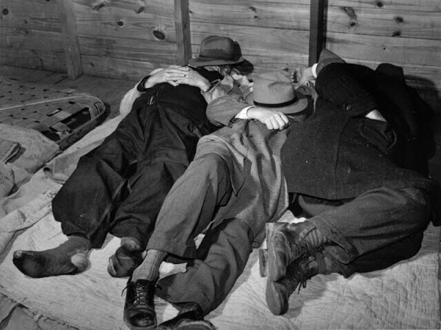 Бедные фермеры спят в помещении на товарном складе. Часто им приходилось оставаться там на несколько дней - пока не будет продан весь табак. Дарем, Северная Каролина, 1939 год