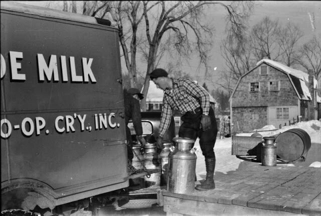 Фермеры из пригорода каждое утро рано утром привозят бидоны с молоком на перекресток, откуда его забирает грузовик и везет в город, март 1940 г.  Вудсток, штат Вермонт