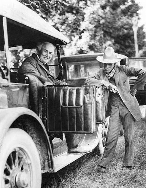 Томас Эдисон (1847-1931, слева) улыбается, сидя в машине, и позирует со своим другом и коллегой промышленным магнатом Генри Фордом (1863-1947).
