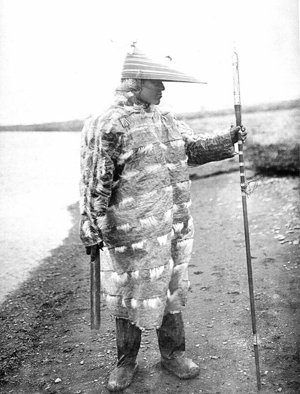 Алеут-охотник в традиционной непромокаемой одежде из кишок морского льва (Аляска, 1905 год)